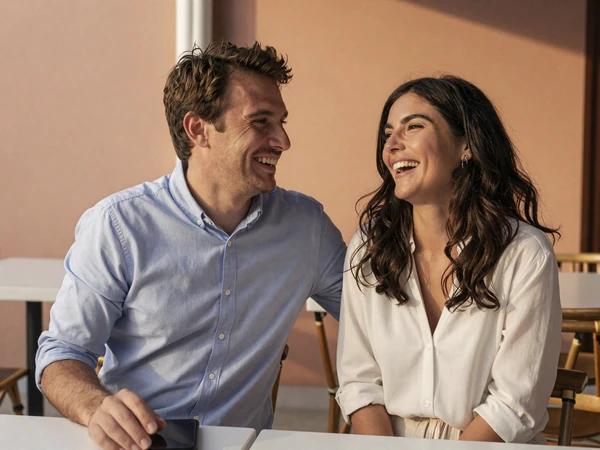 American man and Balkan woman enjoying a date at a Mediterranean café, international dating couple