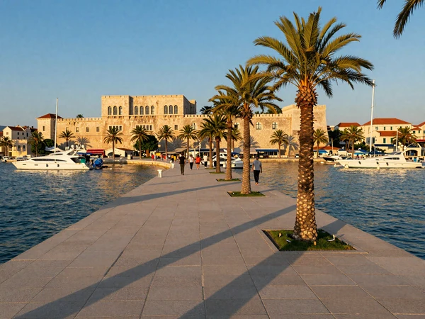 Split Riva promenade at golden hour with Diocletian Palace and palm trees - waterfront Croatian date